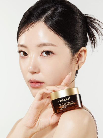 Woman holding a skincare product with a plain background