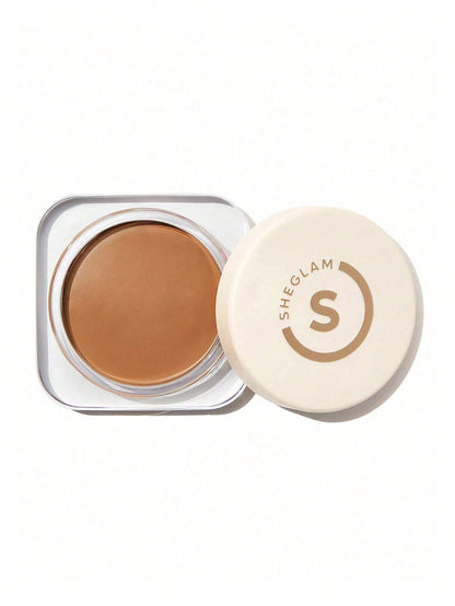 Sheglam cosmetic cream in a clear container with a white lid on a white background